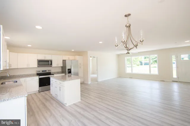 a large kitchen with cabinets wooden floor and stainless steel appliances