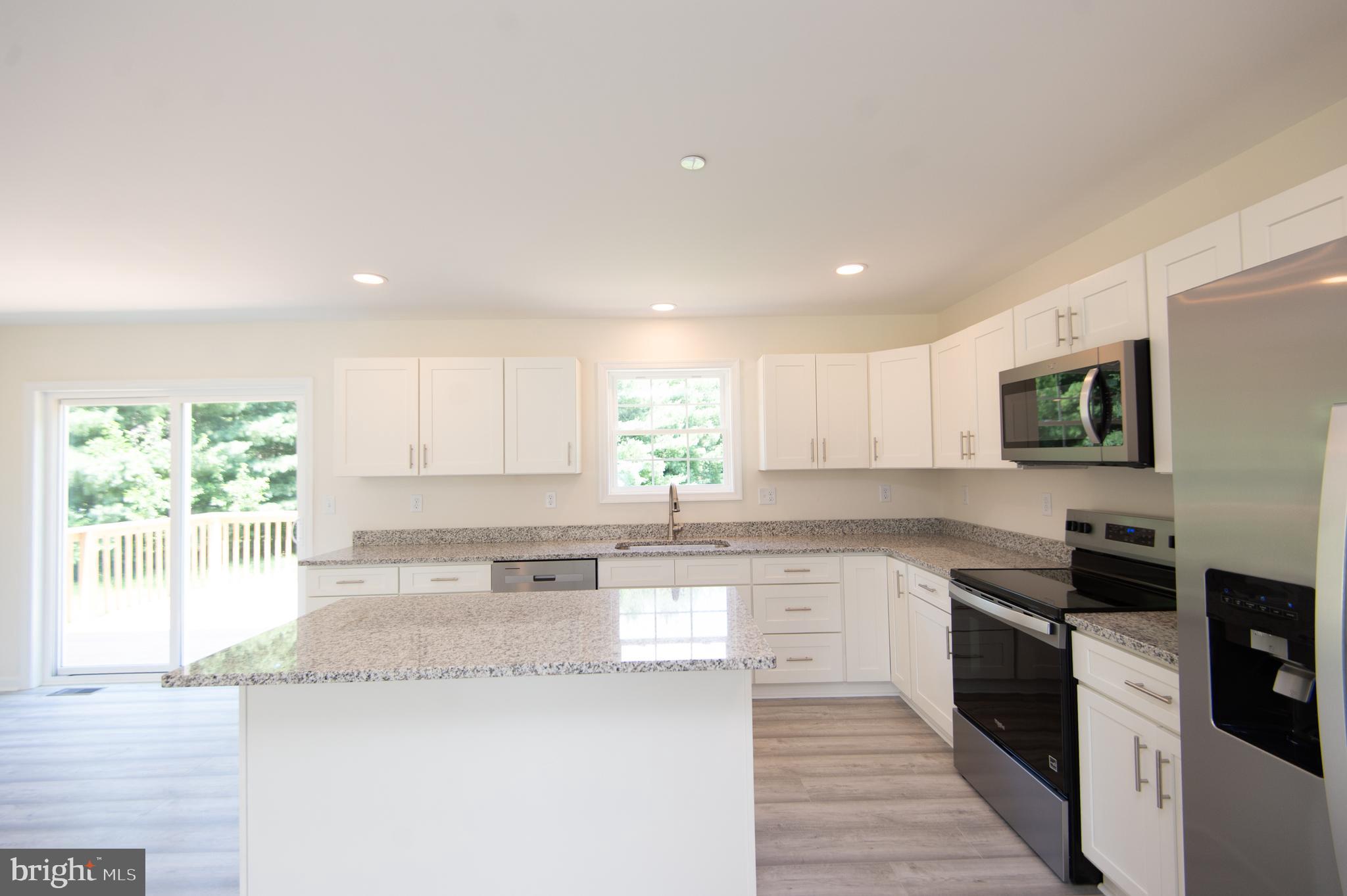 6706 Jayar Way Hurlock, MD 21643 - Photo 4 of 19 a kitchen with granite countertop white cabinets and stainless steel appliances
