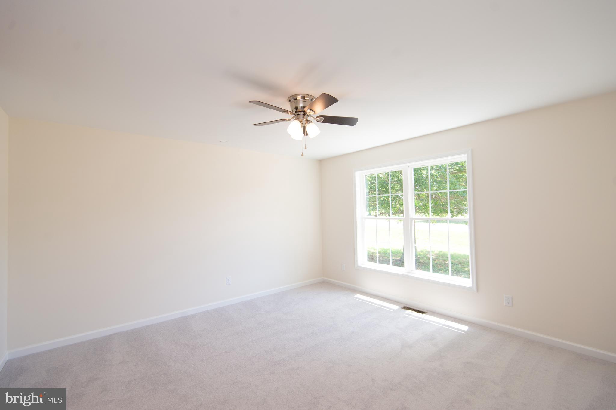 6706 Jayar Way Hurlock, MD 21643 - Photo 6 of 19 an empty room with a window and a ceiling fan