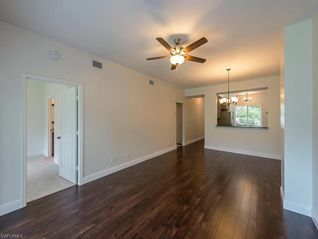 5470 16th Place Southwest, Unit 103 Naples, FL 34116 - Photo 3 of 12 a view of an empty room with wooden floor and a window