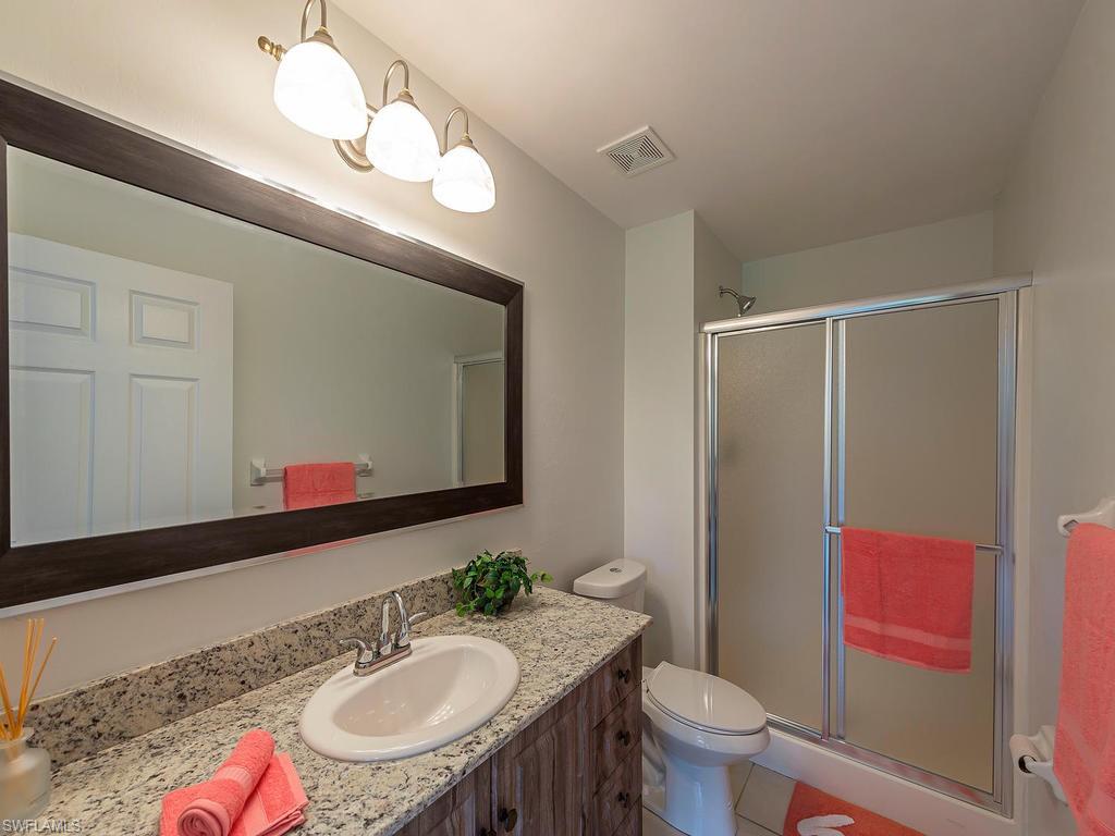 5470 16th Place Southwest, Unit 103 Naples, FL 34116 - Photo 5 of 12 a bathroom with a toilet a sink and a mirror
