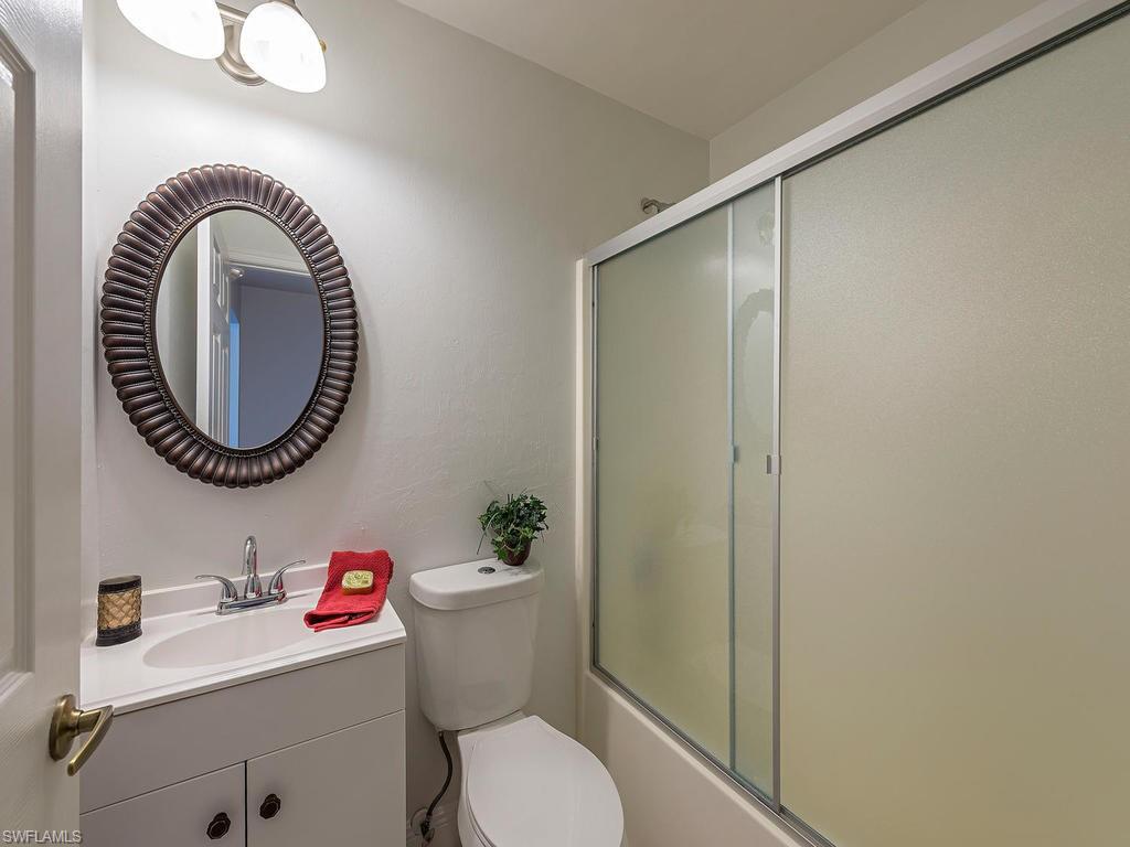 5470 16th Place Southwest, Unit 103 Naples, FL 34116 - Photo 10 of 12 a white toilet sitting next to a bathroom sink