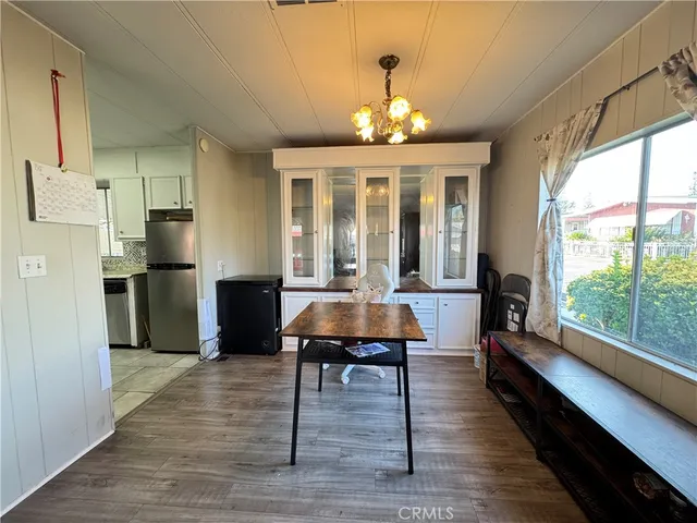 a view of a dining room with furniture a chandelier and wooden floor