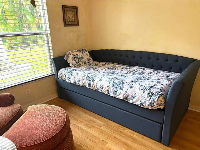 a bed sitting in a bedroom next to a window