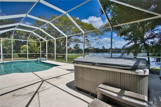 a view of a backyard with couches under an umbrella