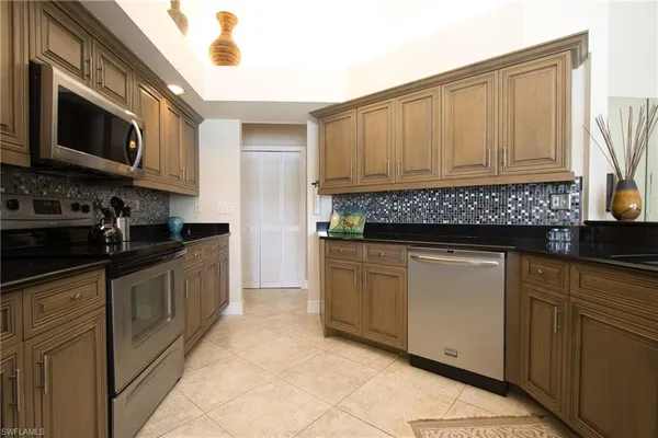 a kitchen with stainless steel appliances granite countertop a sink a stove and cabinets