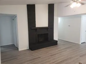 a view of a livingroom with wooden floor and a fireplace