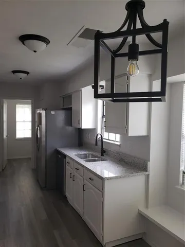 a kitchen with stainless steel appliances granite countertop a sink a refrigerator and a stove