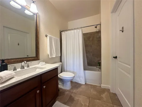 a bathroom with a granite countertop toilet sink and mirror