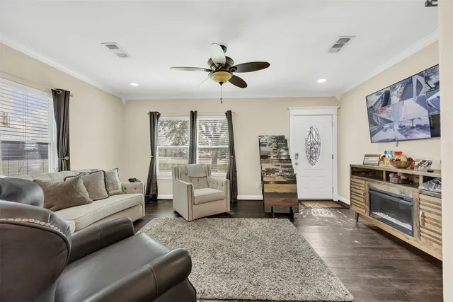 a living room with furniture and wooden floor
