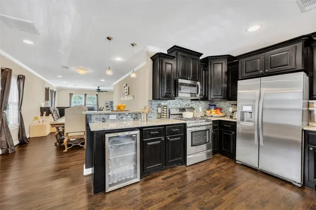 a kitchen with stainless steel appliances granite countertop a refrigerator a sink dishwasher a stove and a refrigerator