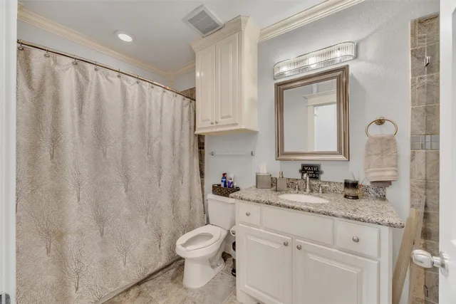 a bathroom with a granite countertop sink toilet and mirror