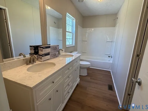a bathroom with a sink double vanity granite tub and a mirror