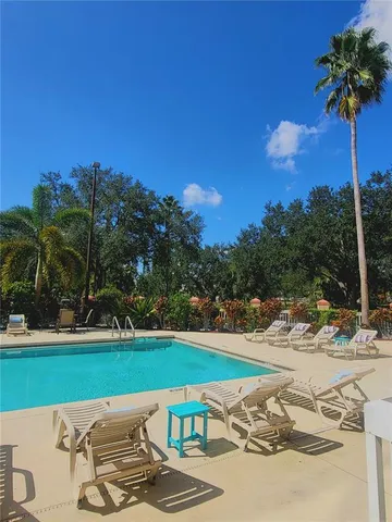 a view of a swimming pool with a yard and sitting area