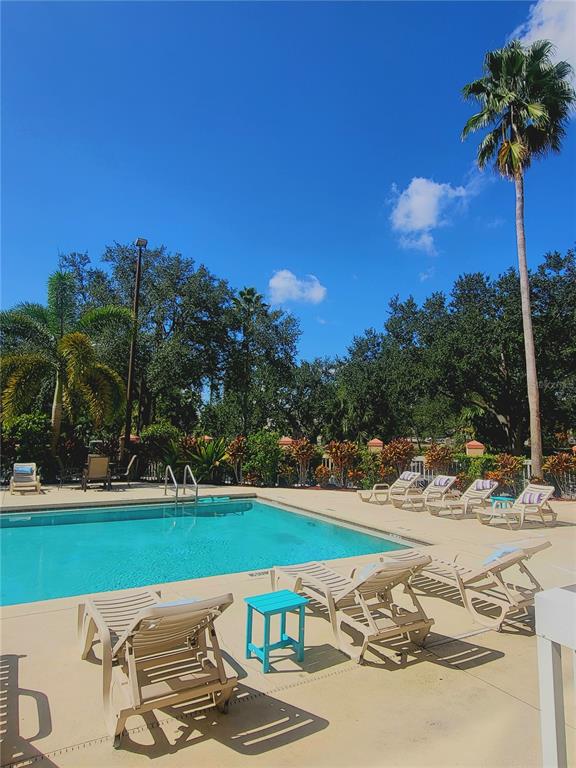 3000 Maingate Lane, Unit 517 Kissimmee, FL 34747 - Photo 12 of 13 a view of a swimming pool with a yard and sitting area