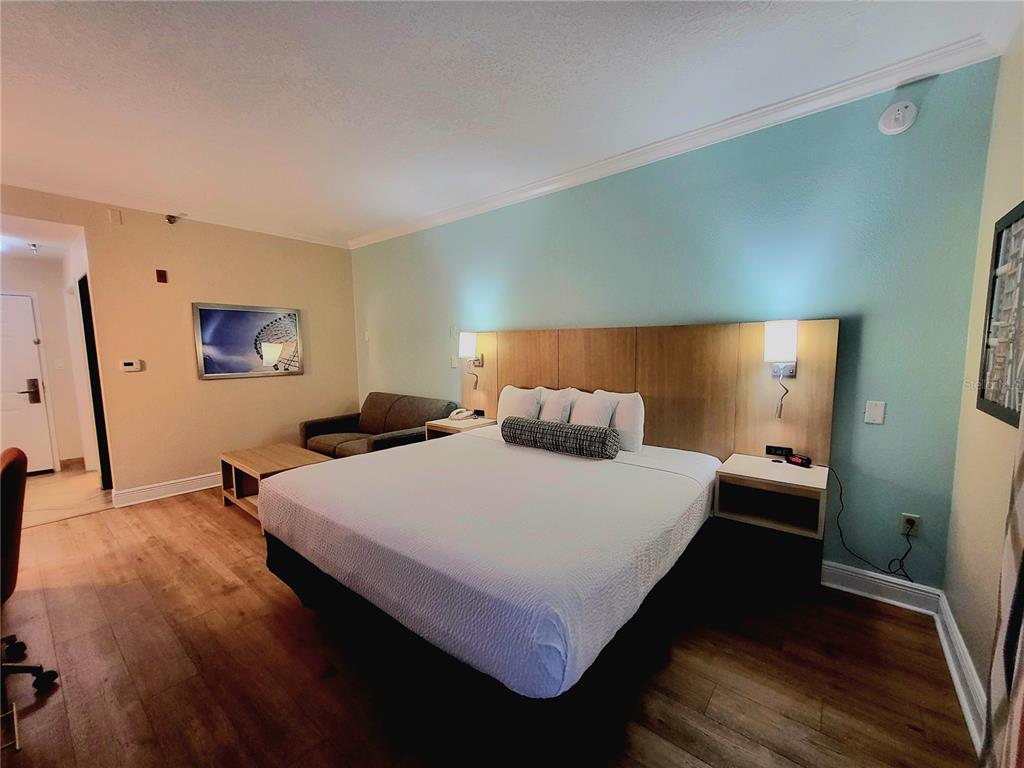 3000 Maingate Lane, Unit 517 Kissimmee, FL 34747 - Photo 6 of 13 a bedroom with a bed and wooden floor