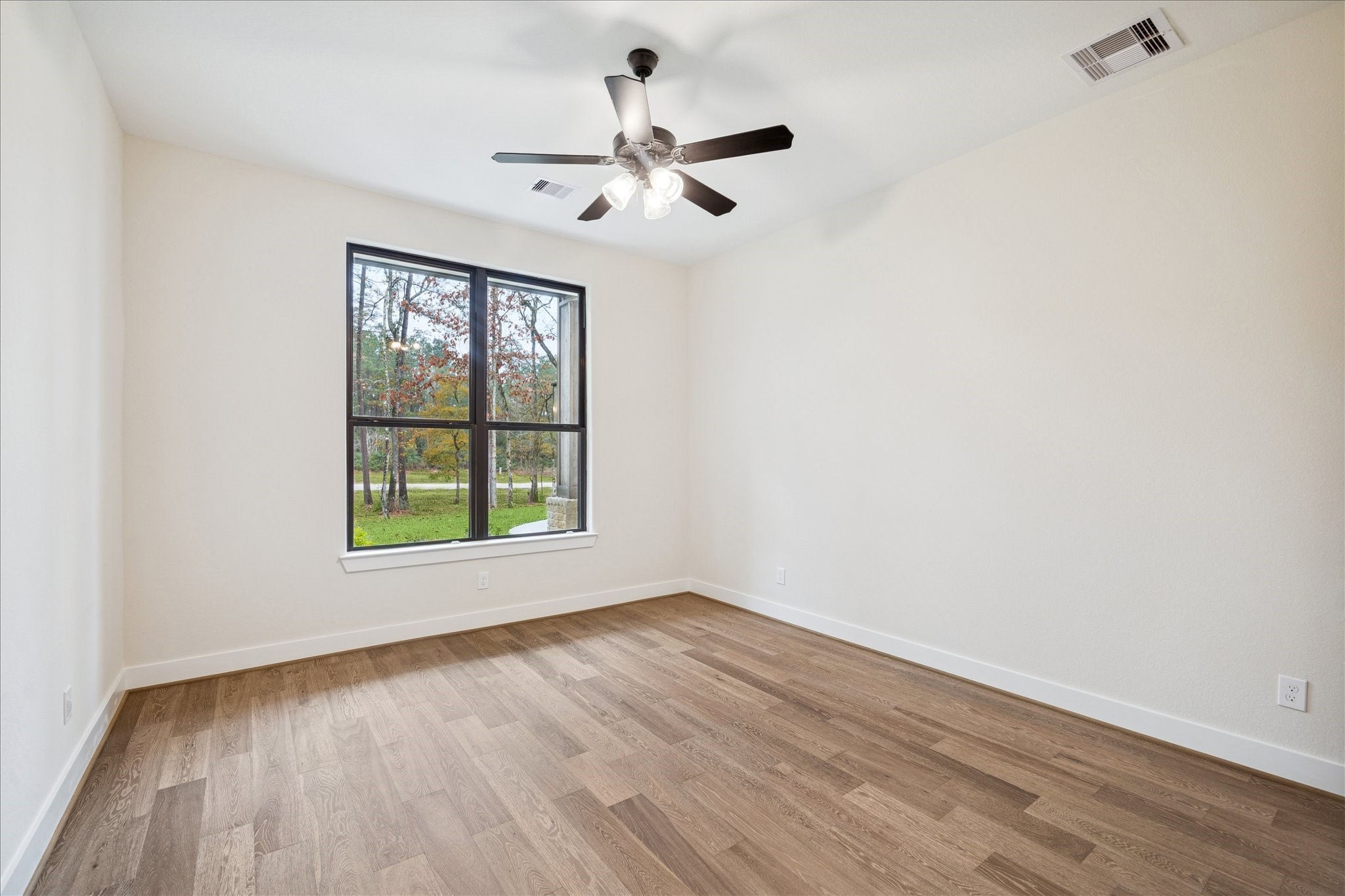 104 Dawn Court Huntsville, TX 77340 - Photo 28 of 37 an empty room with wooden floor fan and windows