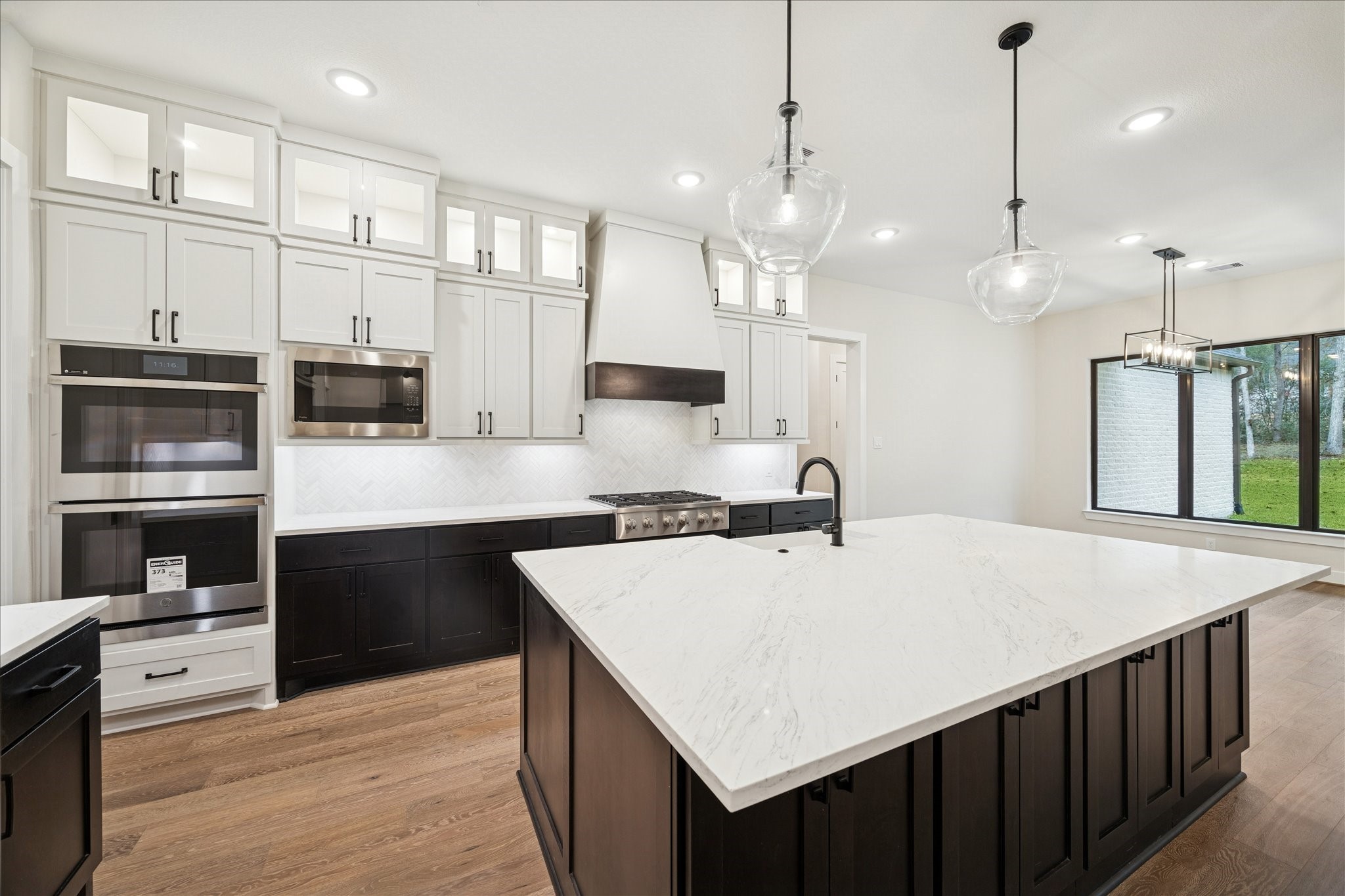 104 Dawn Court Huntsville, TX 77340 - Photo 3 of 37 a large kitchen with kitchen island a stove a sink dishwasher and a refrigerator with wooden floor