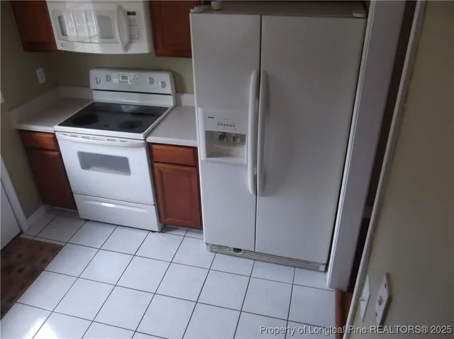 a kitchen with white cabinets and white appliances