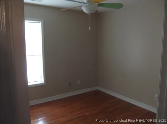a view of a small space with wooden floor and a window