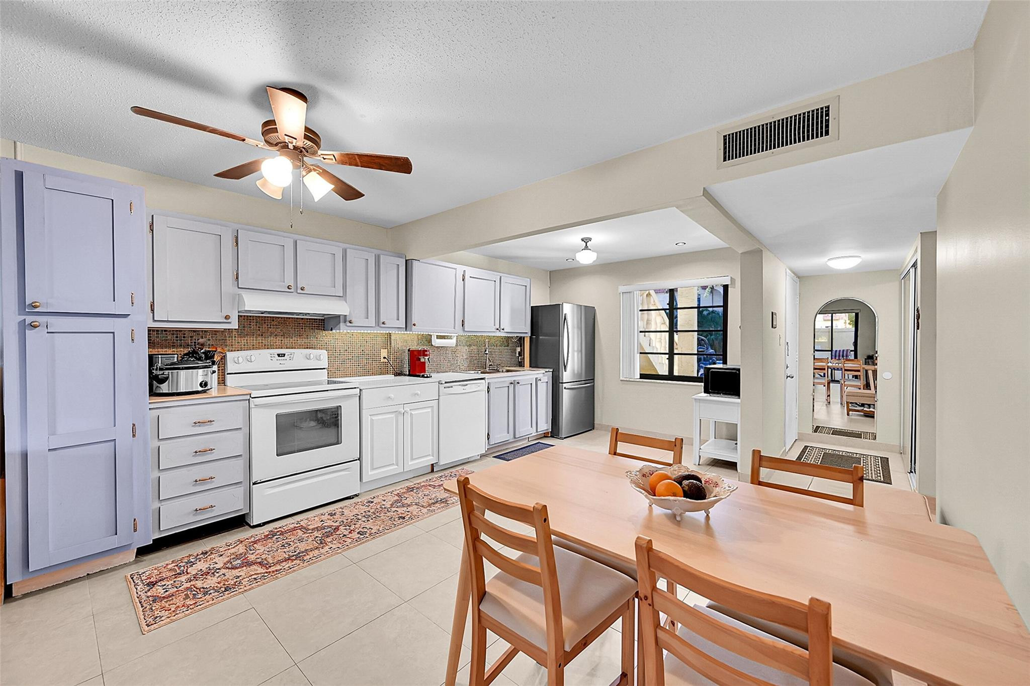 a kitchen with white cabinets and white appliances