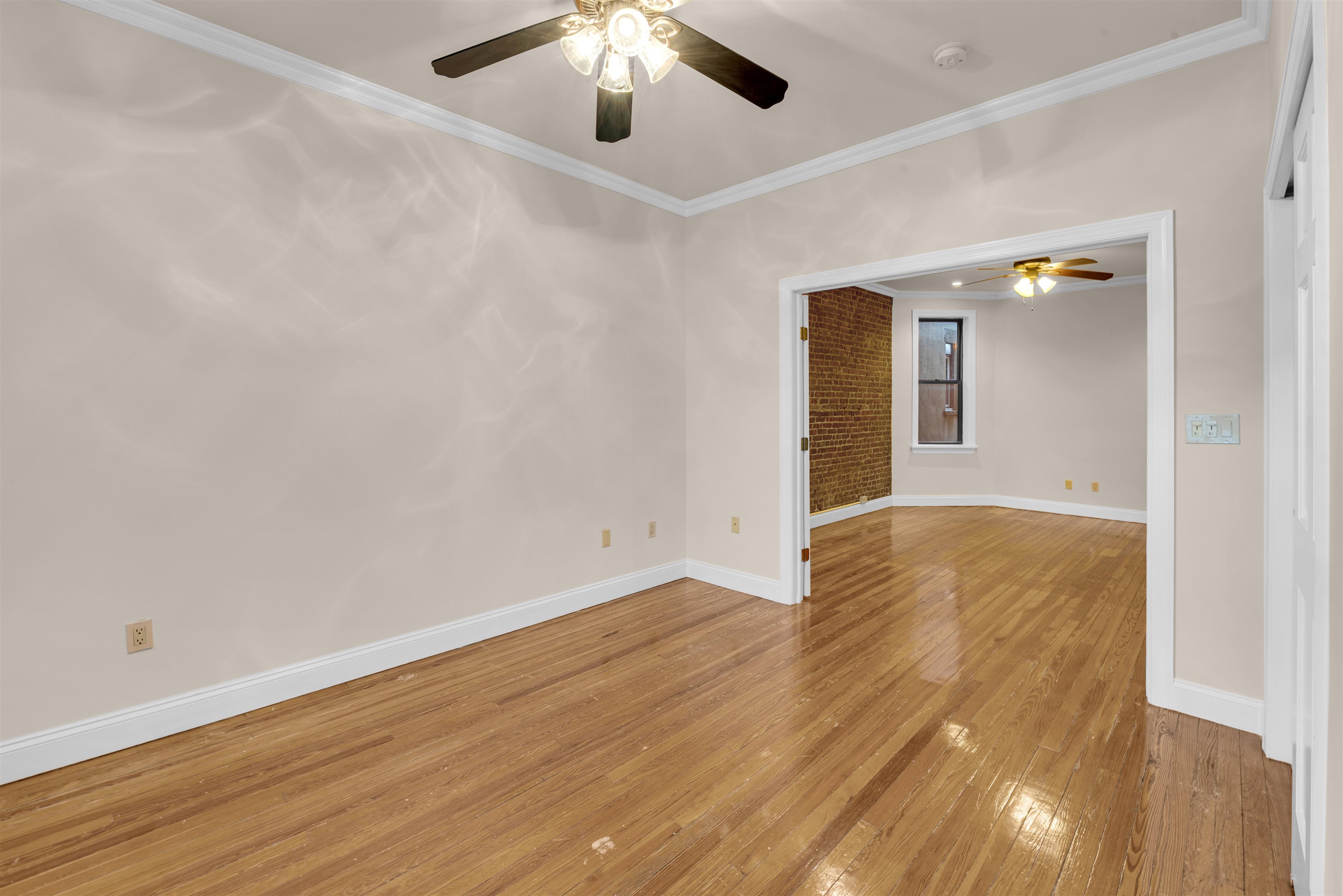 312 Monastery Place, Unit 2R Union City, NJ 07087 - Photo 4 of 15 an empty room with wooden floor and chandelier fan