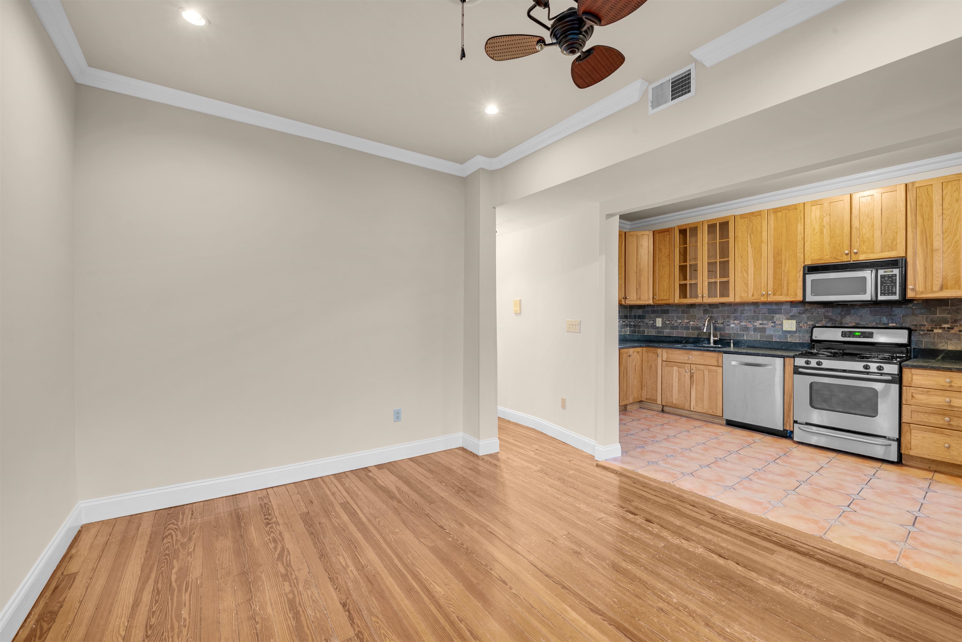 312 Monastery Place, Unit 2R Union City, NJ 07087 - Photo 5 of 15 a kitchen with granite countertop wooden floors stainless steel appliances and a window