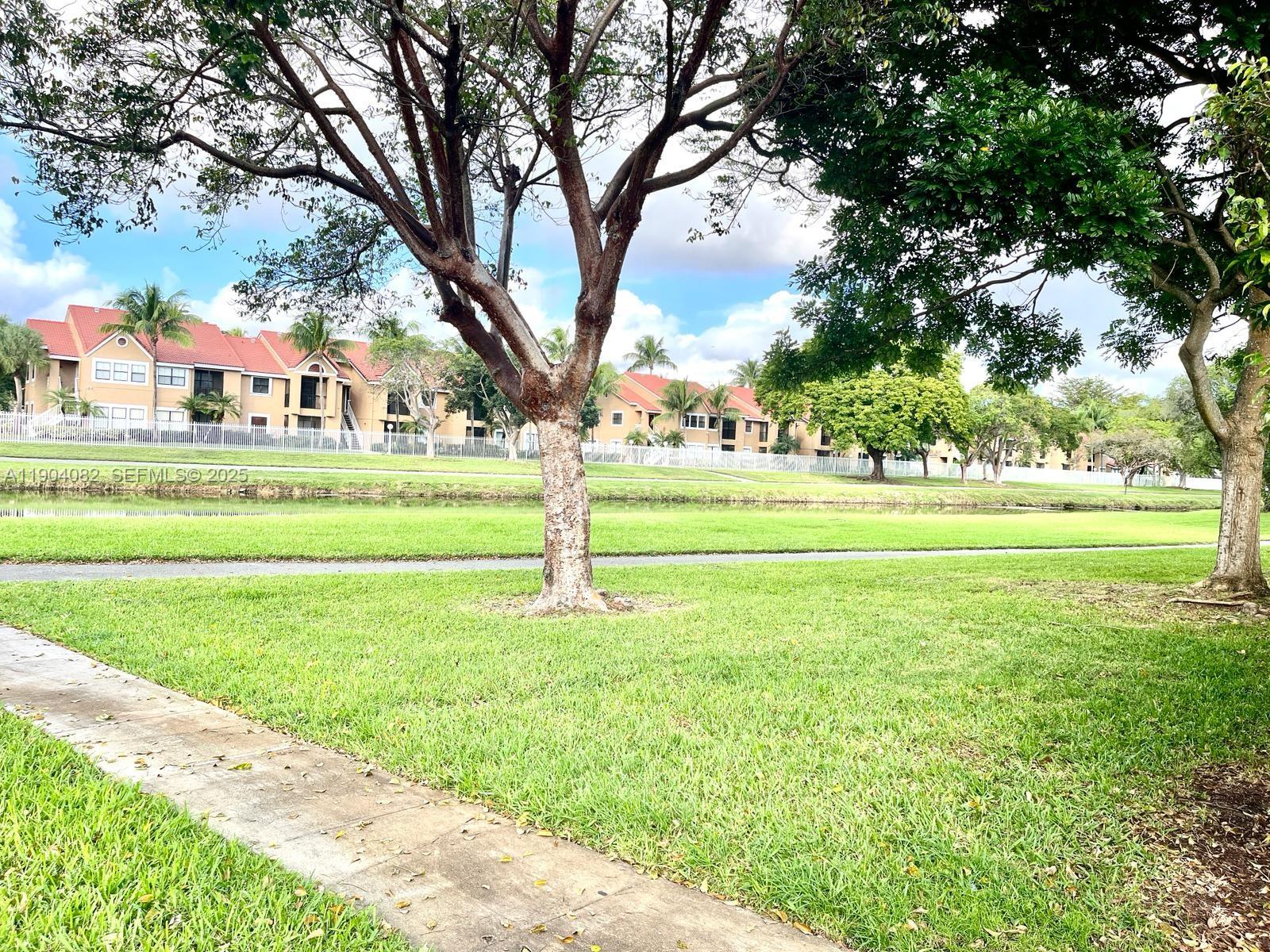 10445 Southwest 154th Court, Unit 2 Miami, FL 33196 - Photo 9 of 11 a big yard with lots of green space and trees