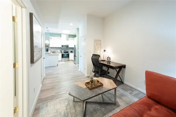 a living room with furniture and a dining table with wooden floor