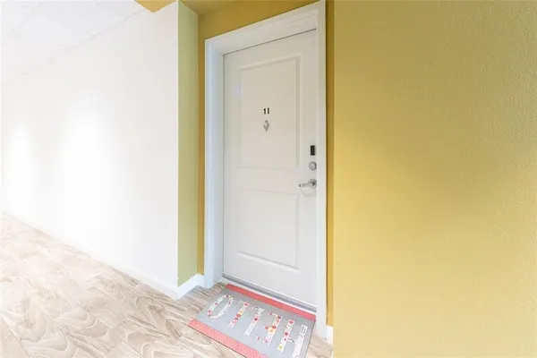 a view of a hallway with wooden floor and a bathroom