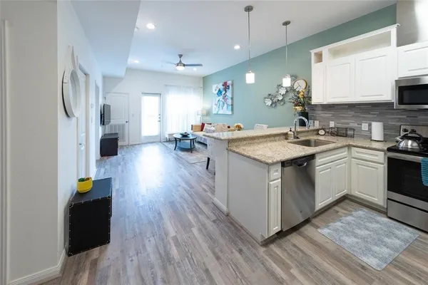 a kitchen with a sink stove and wooden floor