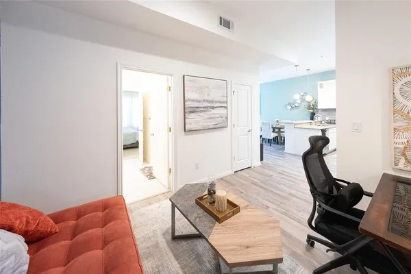 a living room with furniture and a wooden floor
