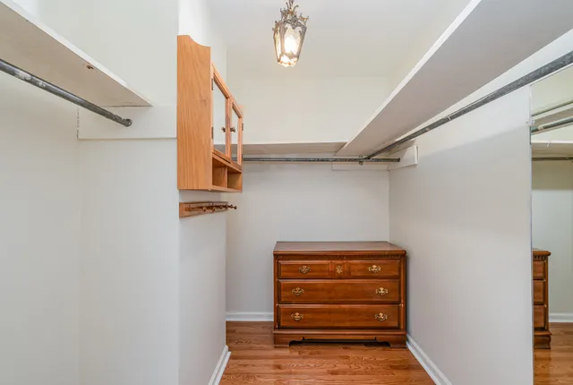a view of walk in closet with clothes and shoes