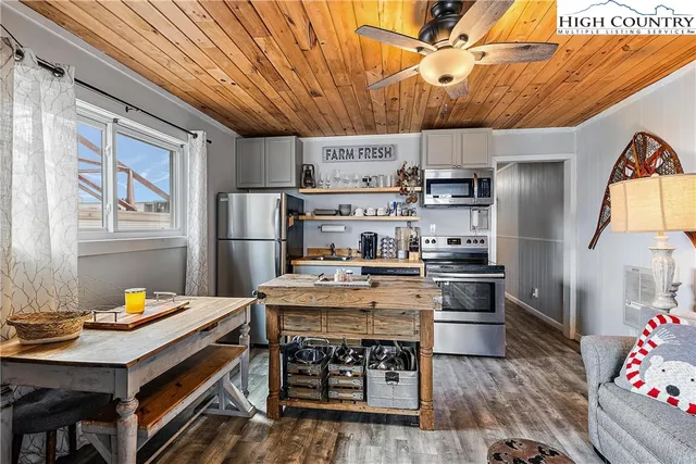 a kitchen with stainless steel appliances a stove a refrigerator and wooden floor