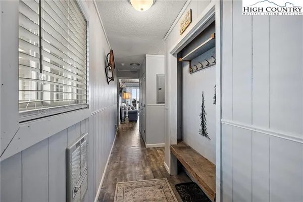 a hallway with wooden floor windows and entryway