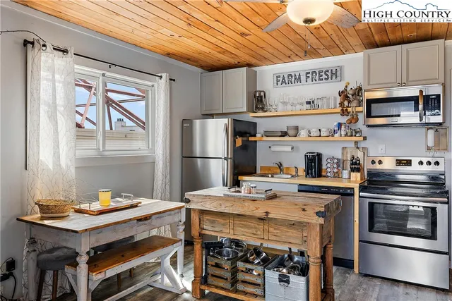 a kitchen with kitchen island a stove a refrigerator and a table