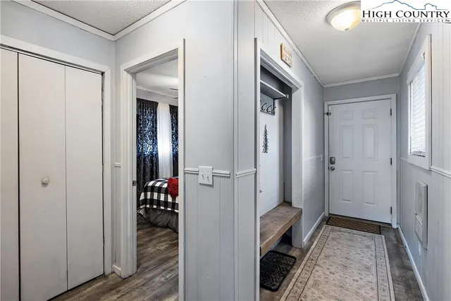 a hallway with white doors wooden floor and stairs