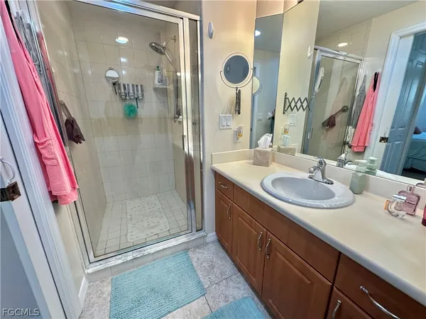 a bathroom with a sink a mirror a vanity and shower