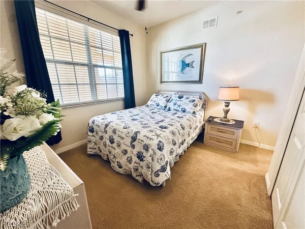 a bedroom with a bed lamp and a window