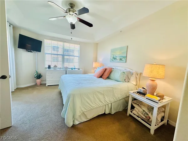 a bedroom with a bed and a ceiling fan