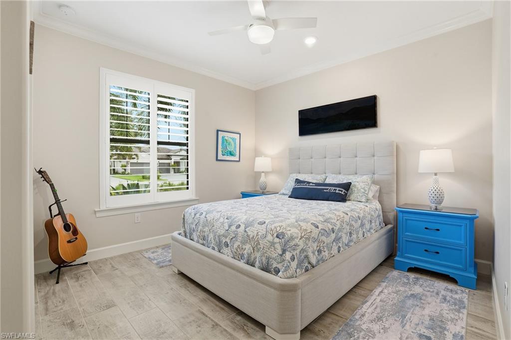 17210 Ashcomb Way Estero, FL 33928 - Photo 25 of 47 a bedroom with a bed and a flat tv screen on wall