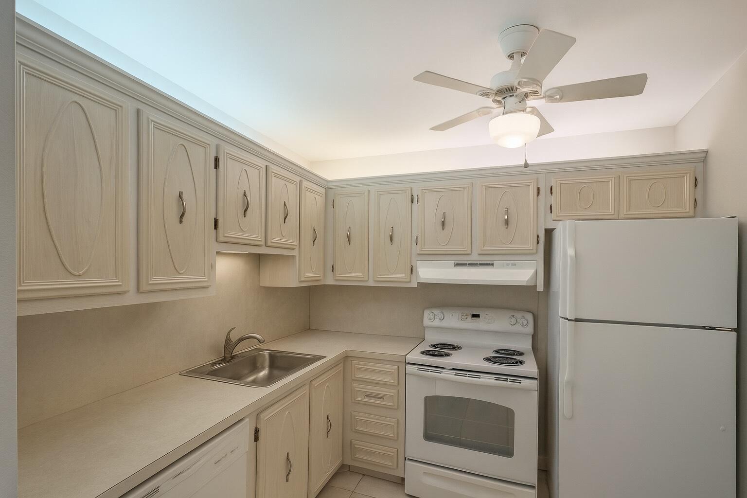 375 Southwest 56th Avenue, Unit 217 Margate, FL 33068 - Photo 2 of 15 a kitchen with a sink a refrigerator a stove and cabinets