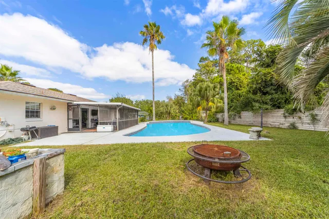 a house view with swimming pool and trees in front of it