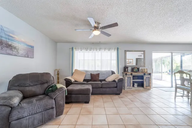 a living room with furniture a fireplace and a large window