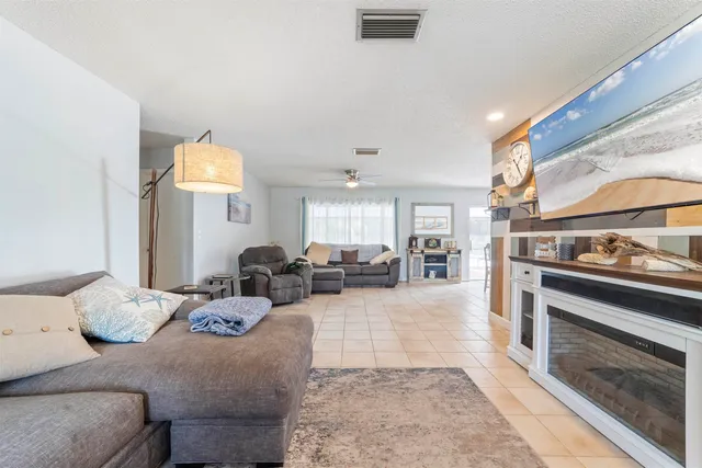 a living room with furniture and a open kitchen view