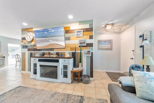 a view of a dining room and livingroom with furniture wooden floor a rug and a chandelier
