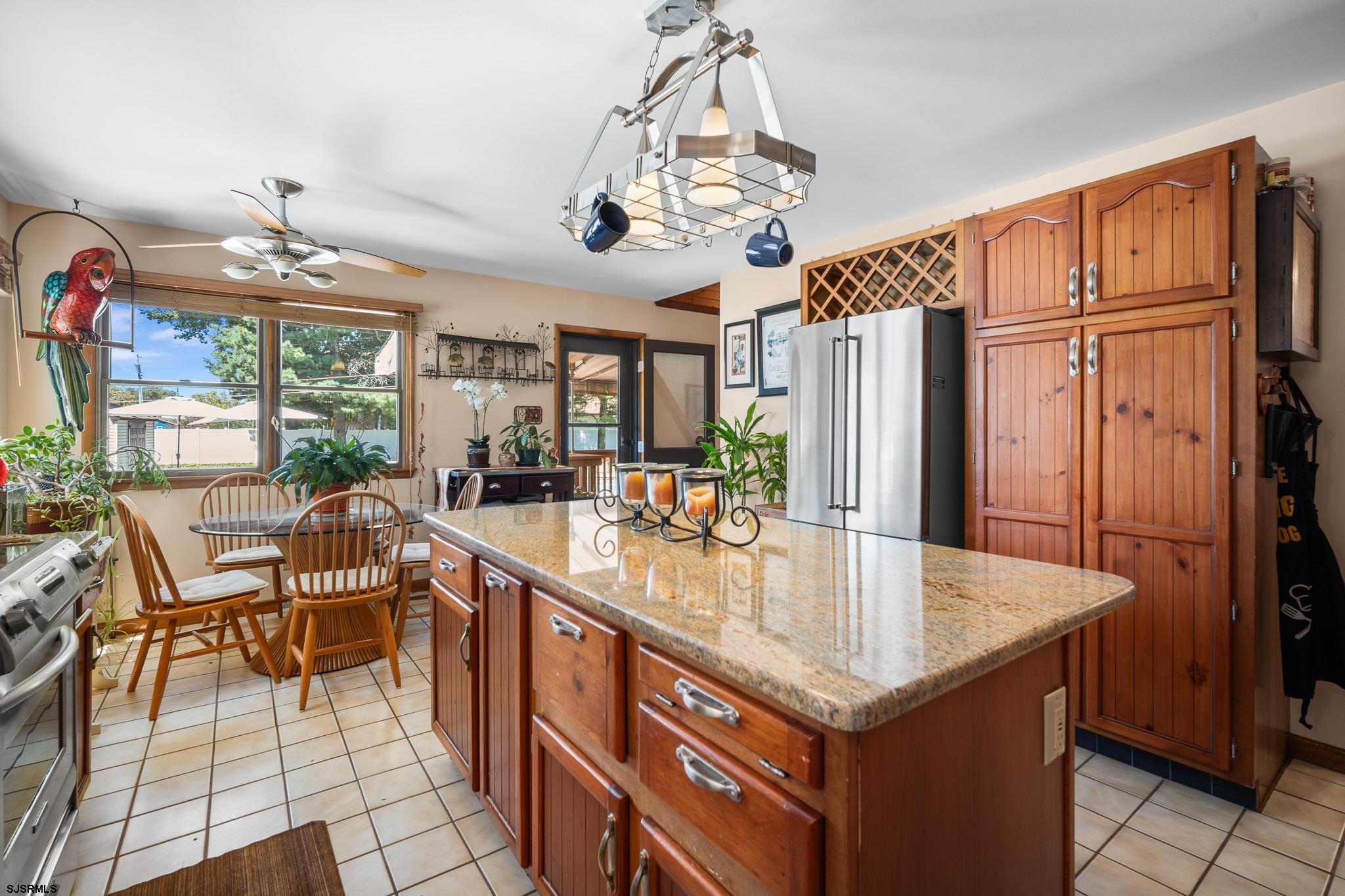 202 North Shore Road Marmora, NJ 08223 - Photo 17 of 31 a kitchen with stainless steel appliances granite countertop a table chairs and a refrigerator