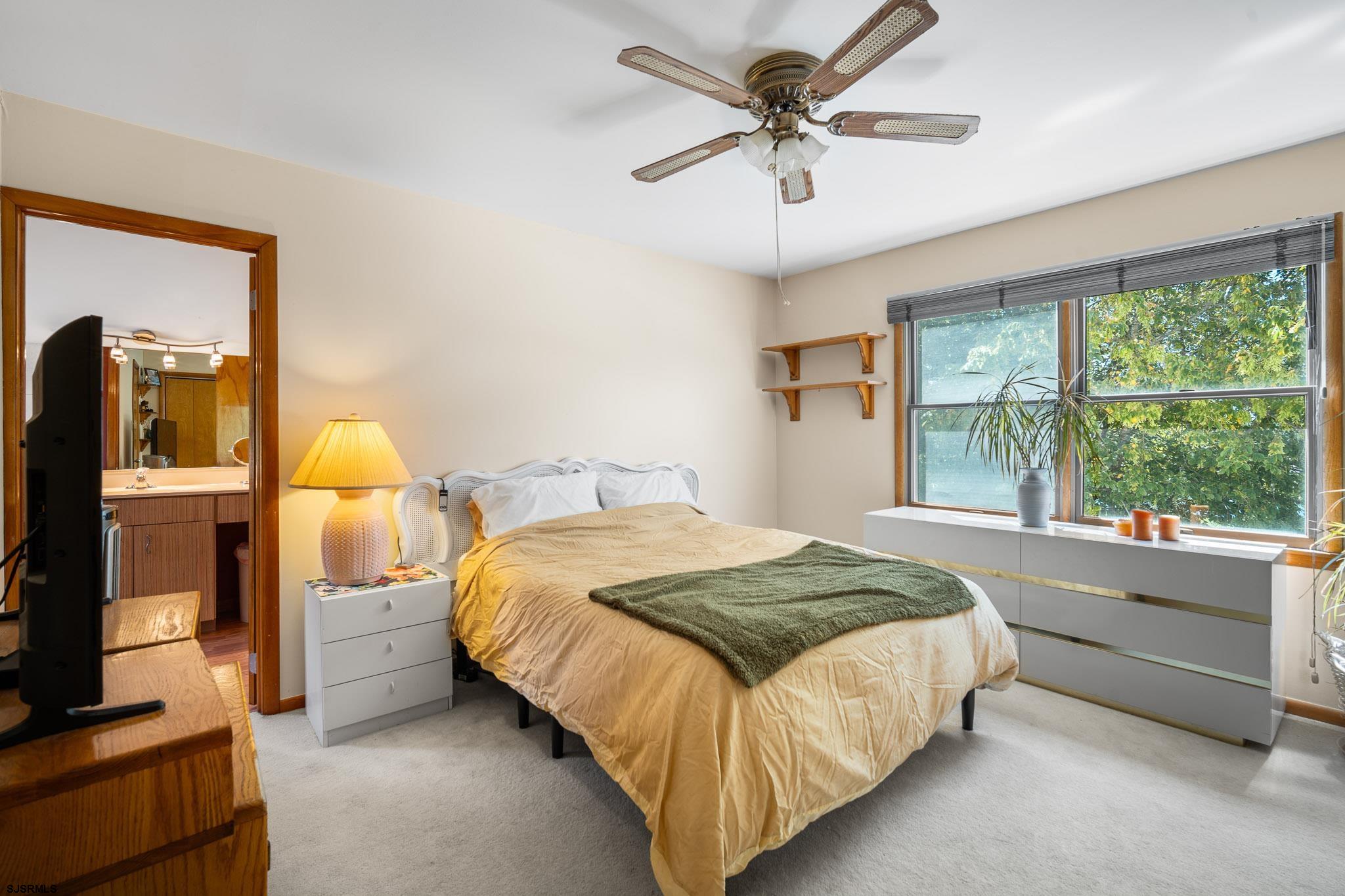 202 North Shore Road Marmora, NJ 08223 - Photo 25 of 31 a bedroom with a bed flat screen tv and a large window