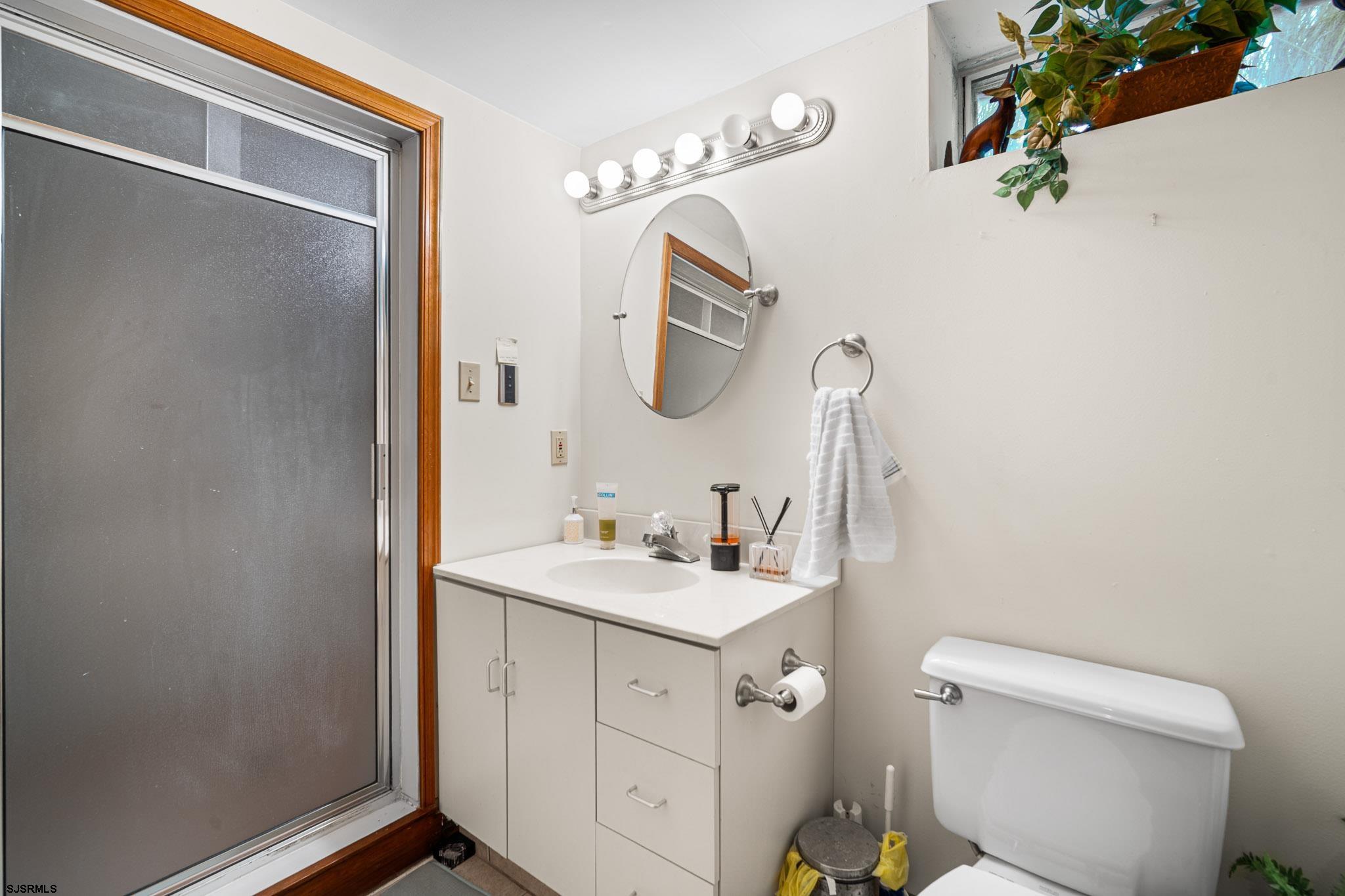 202 North Shore Road Marmora, NJ 08223 - Photo 30 of 31 a bathroom with a toilet sink and mirror