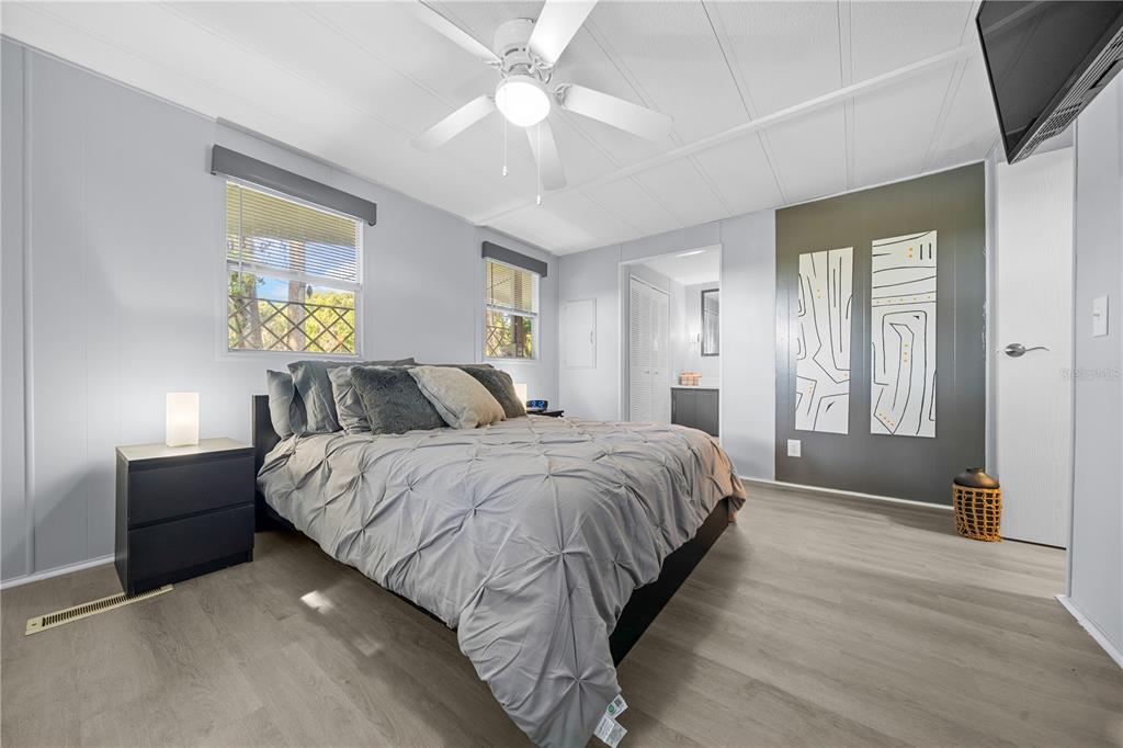 426 Northwest 5th Road Lake Panasoffkee, FL 33538 - Photo 13 of 51 a spacious bedroom with a bed and a chandelier